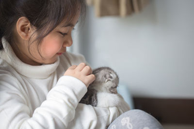 Close-up of girl holding kitten