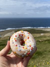 Cropped hand of woman holding donut