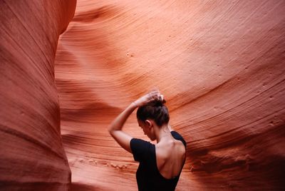 Rear view of woman standing on rock