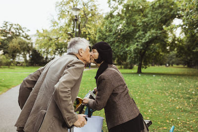 Senior couple kissing on mouth in park during vacation