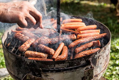 Close-up of man preparing food on barbecue grill