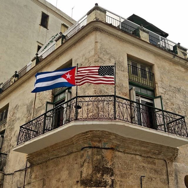 architecture, building exterior, built structure, low angle view, flag, patriotism, window, building, identity, national flag, city, sky, american flag, day, residential structure, residential building, facade, outdoors, red, no people