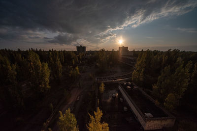 High angle view of trees and buildings against sky during sunset