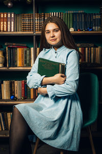 Young woman sitting on book