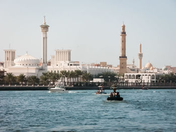 People in front of sea against clear sky