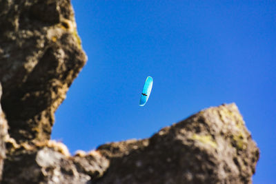 Low angle view of rocks against blue sky