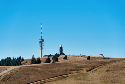 Tower on land against clear blue sky