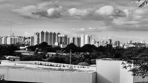 Buildings in city against cloudy sky