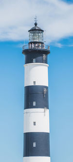 Lighthouse by sea against sky