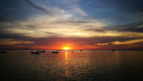 Scenic view of sea against dramatic sky during sunset