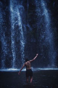 Boy in waterfall