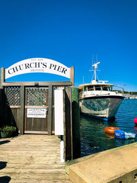 View of ship moored in water against clear blue sky