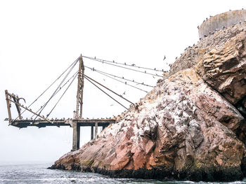 Bridge over sea against clear sky