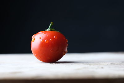 Close-up of tomatoes on table against black background