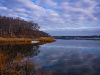 Scenic view of calm lake against cloudy sky