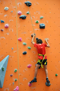 Rear view of boy climbing on rock