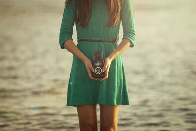 Close-up of young woman holding camera
