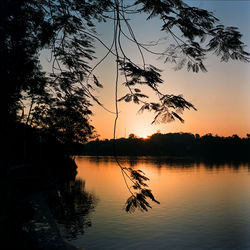 Scenic view of lake against sky at sunset