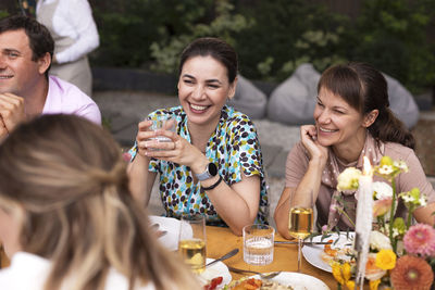 Smiling friends toasting drinks at restaurant