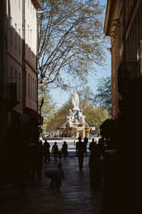 Statue amidst trees and buildings against sky