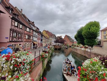 Canal amidst buildings in city against sky