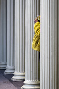 Midsection of person standing by column