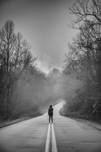 Rear view of man walking on road