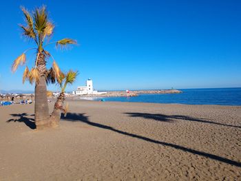 Scenic view of beach against clear blue sky