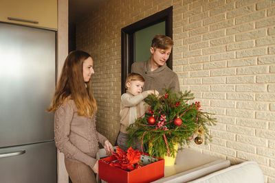 Father with children decorating christmas tree at home