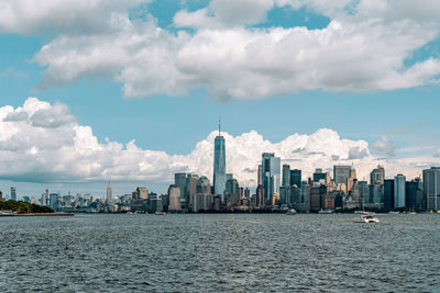 Modern buildings in city against cloudy sky