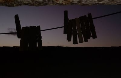 Close-up of clothespins on clothesline against sky