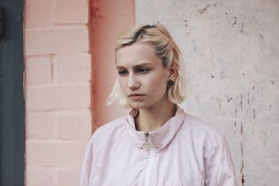 Portrait of woman standing against wall