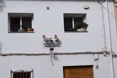 Low angle view of people sitting on balcony of building