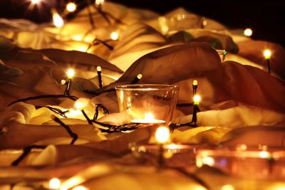 Lit fairy lights and tealight candle on fabric