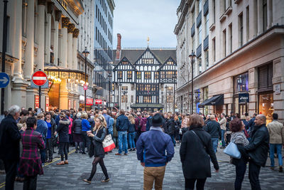 People on street amidst buildings in city