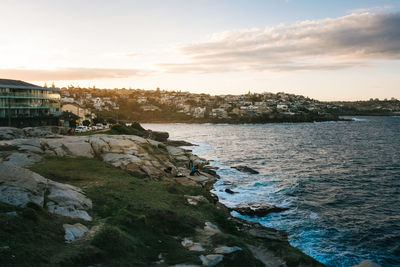 Scenic view of sea by city against sky