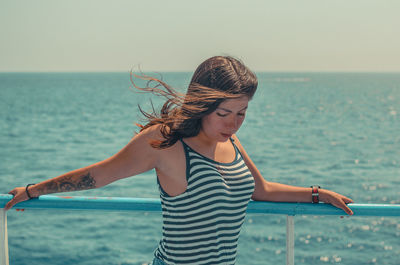 Woman standing against sea with sky in background