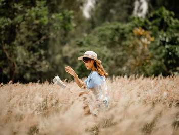 Woman reading book on field