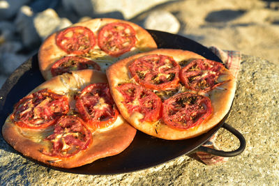 Individual foccacia breads topped with sliced tomato