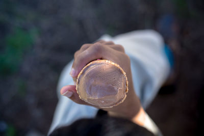 High angle view close-up of kid holding and eating ice cream