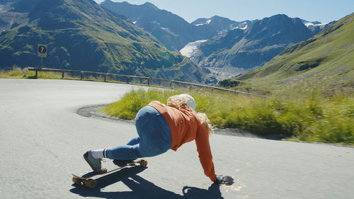 Rear view of woman walking on road