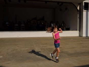 Cute girl running on footpath