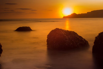 Scenic view of sea against romantic sky at sunset