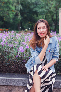 Portrait of beautiful young woman against plants