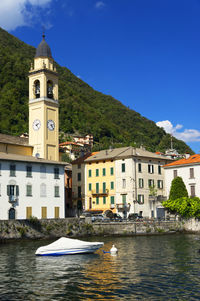 Boat moored in river against built structures