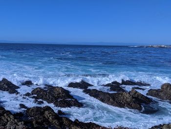 Scenic view of sea against clear blue sky