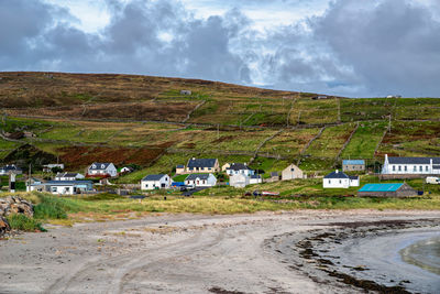 Houses on field against sky