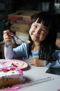 Portrait of smiling girl eating food in plate