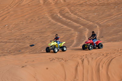 People riding motorcycle on desert