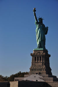 Vertical shot of statue of liberty in new york against a blue sky